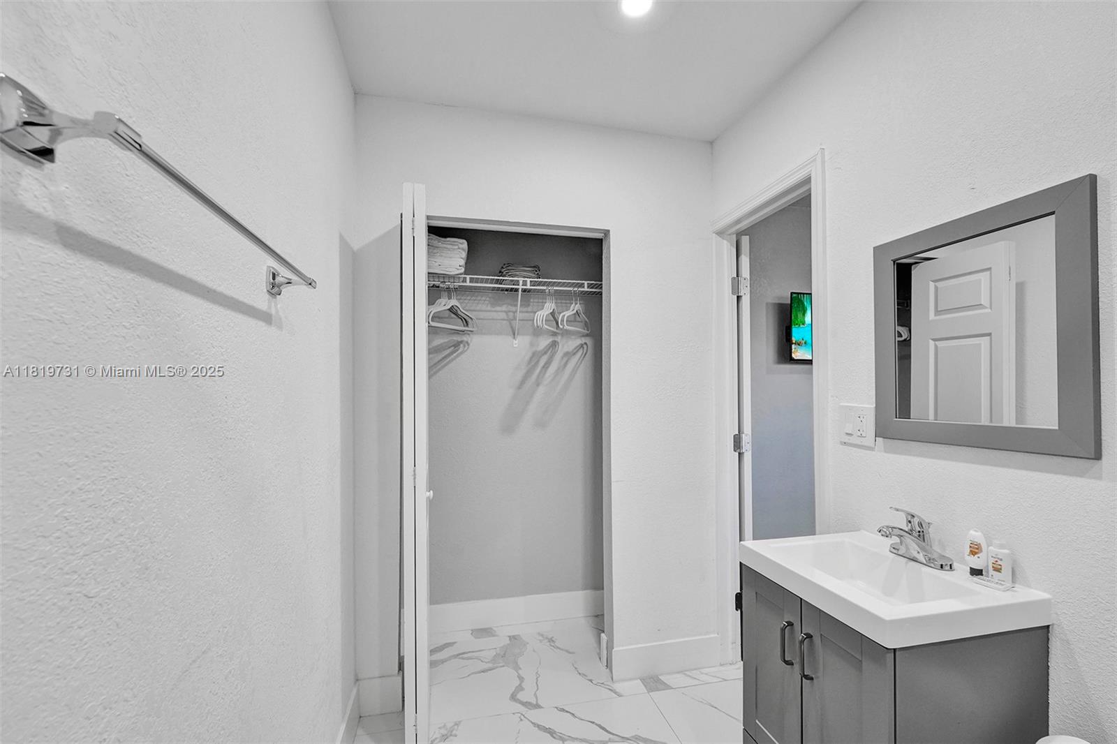 1324 Northeast 151st Street, Unit 1324 Miami, FL 33162 - Photo 18 of 23 a bathroom with a sink mirror and shower