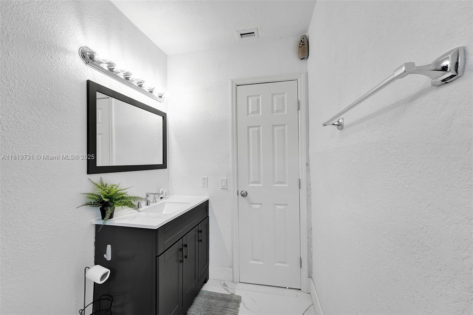 1324 Northeast 151st Street, Unit 1324 Miami, FL 33162 - Photo 19 of 23 a bathroom with a sink vanity and a mirror