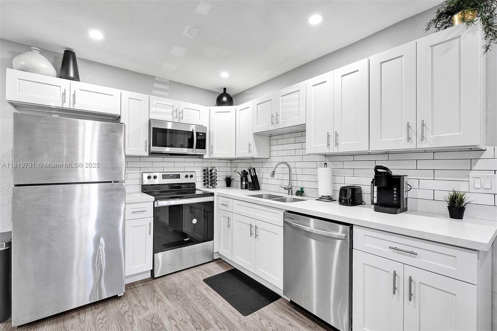 1324 Northeast 151st Street, Unit 1324 Miami, FL 33162 - Photo 2 of 23 a kitchen with stainless steel appliances a refrigerator sink and cabinets