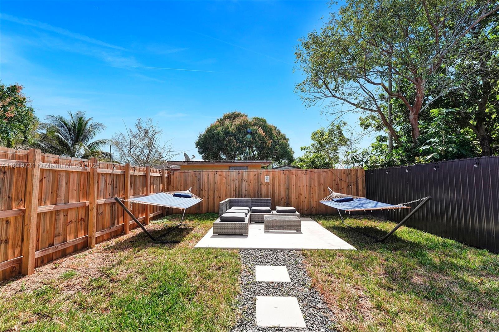 1324 Northeast 151st Street, Unit 1324 Miami, FL 33162 - Photo 22 of 23 a backyard of a house with chairs and wooden fence