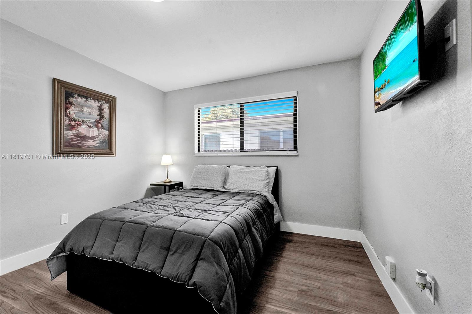 1324 Northeast 151st Street, Unit 1324 Miami, FL 33162 - Photo 3 of 23 a bedroom with a bed and a window