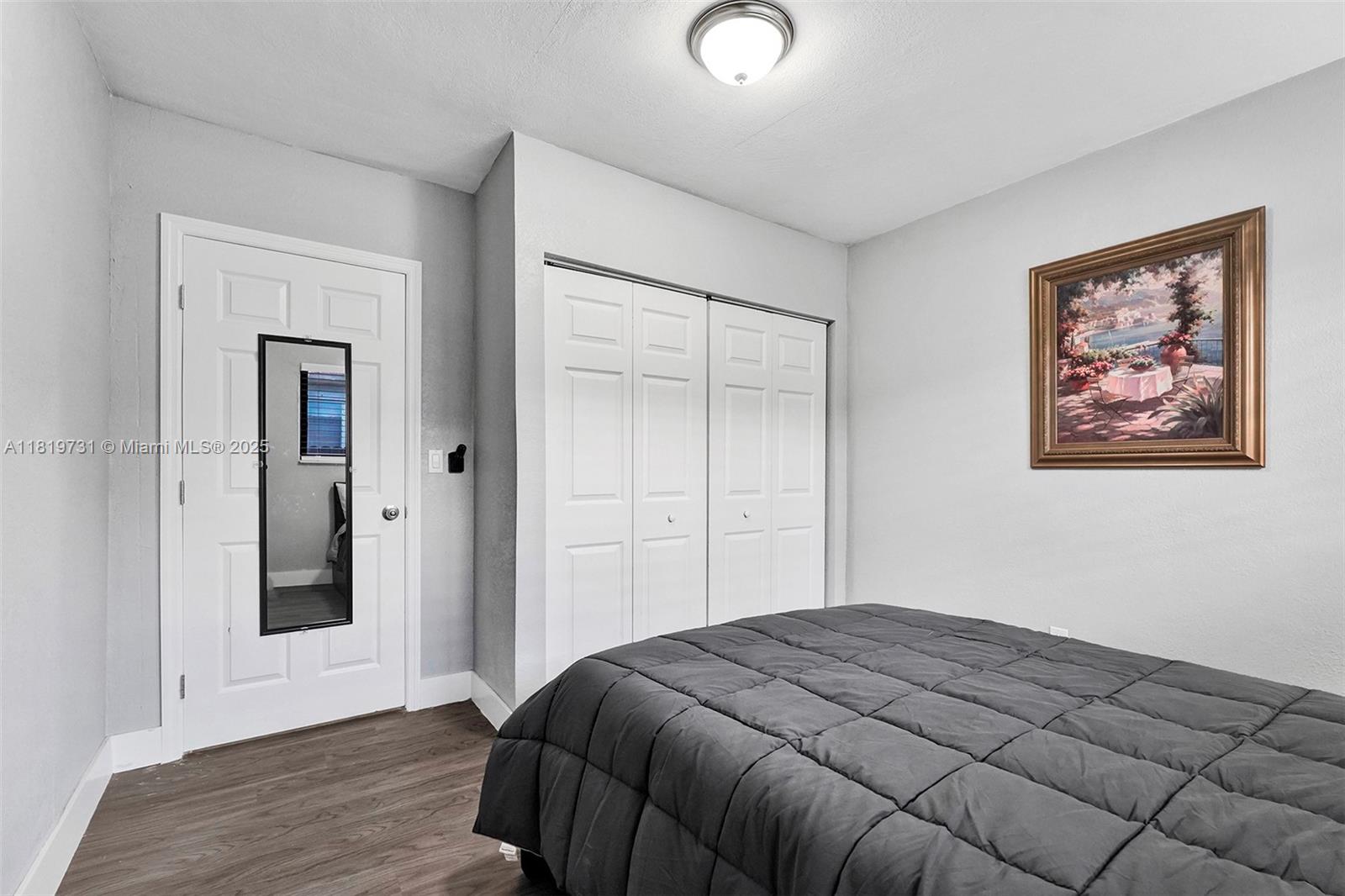 1324 Northeast 151st Street, Unit 1324 Miami, FL 33162 - Photo 4 of 23 a bedroom with a bed and a painting on the wall