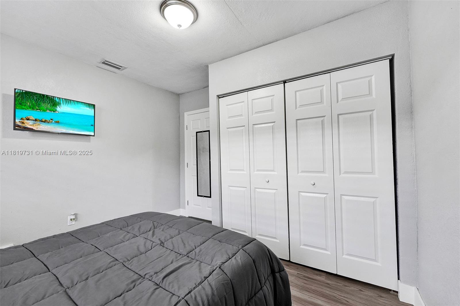 1324 Northeast 151st Street, Unit 1324 Miami, FL 33162 - Photo 5 of 23 a bedroom with a bed and a painting on the wall