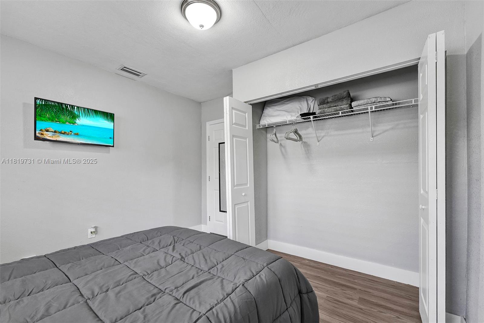 1324 Northeast 151st Street, Unit 1324 Miami, FL 33162 - Photo 6 of 23 a bedroom with a bed and a painting on the wall