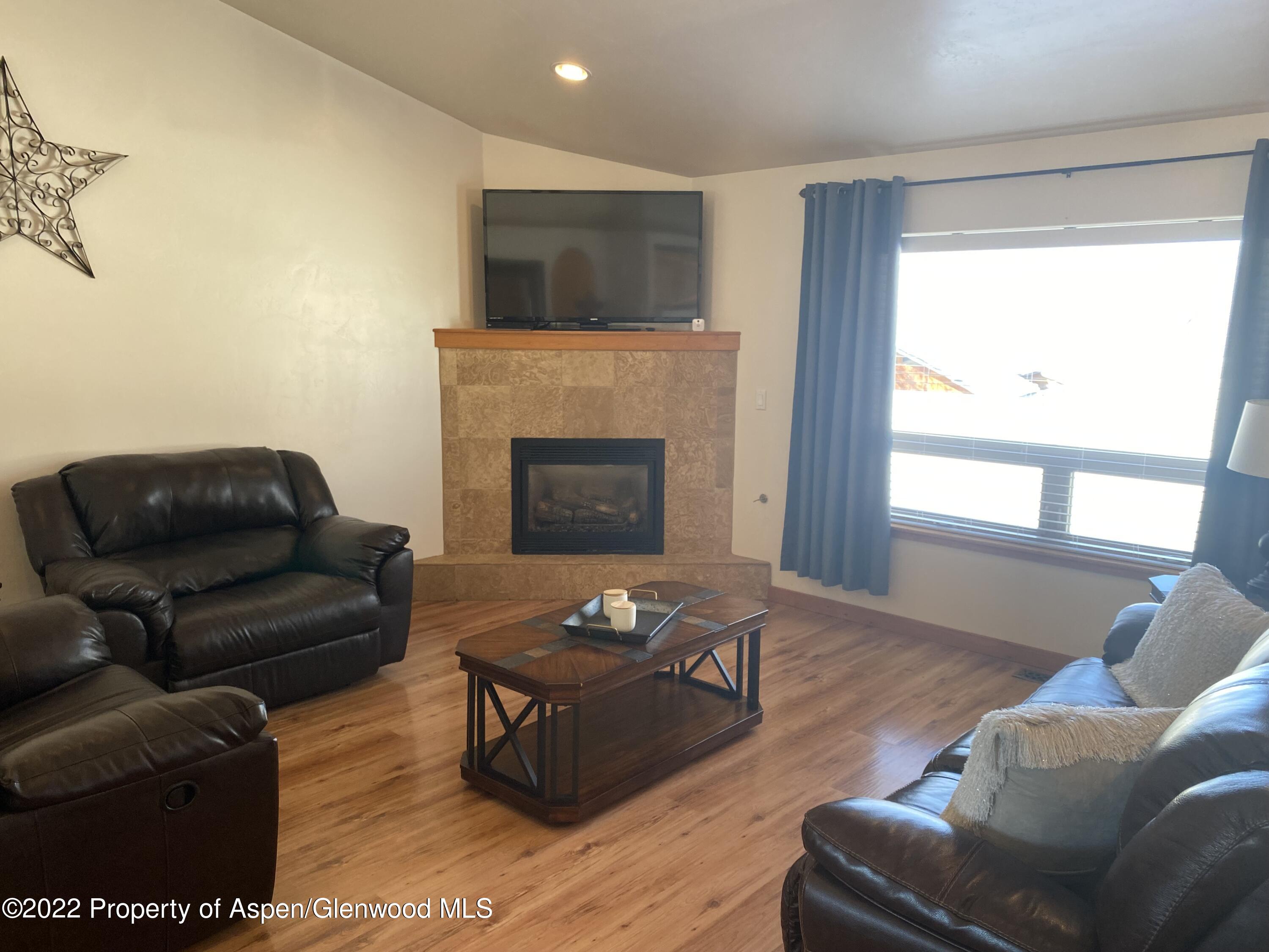 858 East 17th Street Rifle, CO 81650 - Photo 4 of 20 a living room with furniture a flat screen tv and a fireplace