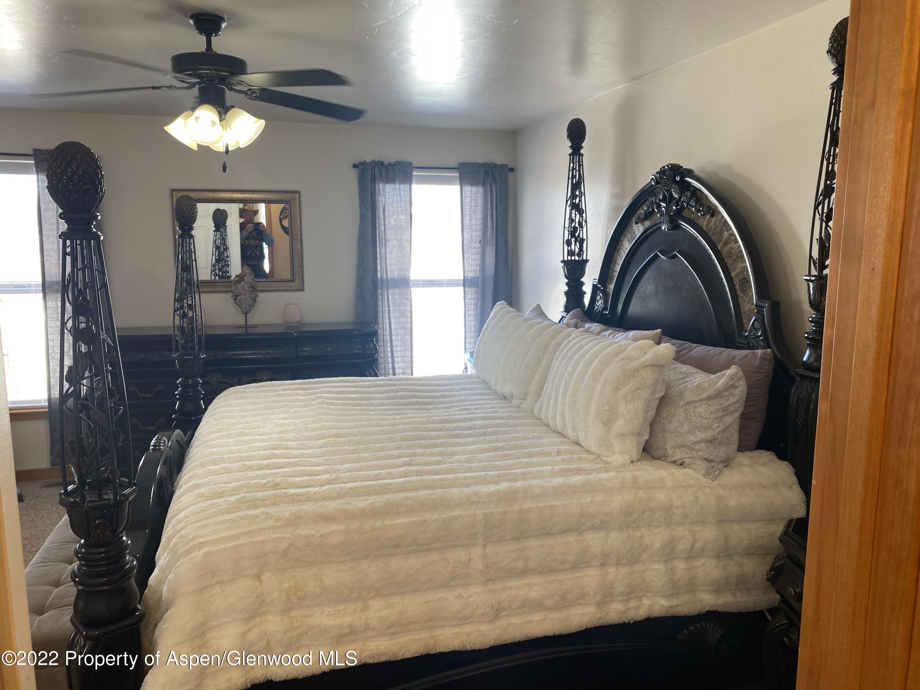 858 East 17th Street Rifle, CO 81650 - Photo 5 of 20 a bedroom with a bed and a chandelier