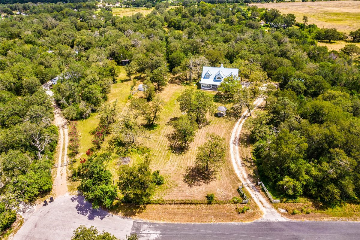 19106 Eyerley Road Manor, TX 78653 - Photo 34 of 40 Nestled amidst verdant woodlands, a charming residence awaits at the end of a winding driveway.