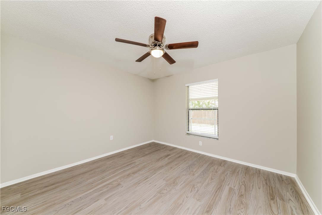 3286 Papaya Road Venice, FL 34293 - Photo 13 of 16 an empty room with wooden floor ceiling fan and windows