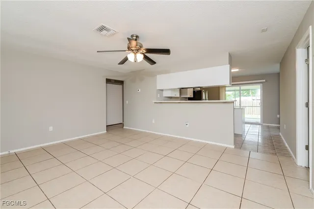 a view of a livingroom with a ceiling fan a kitchen and a window