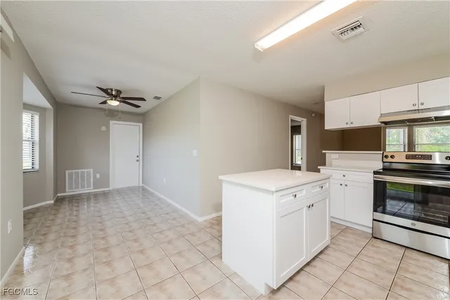 a kitchen with a stove top oven and cabinets