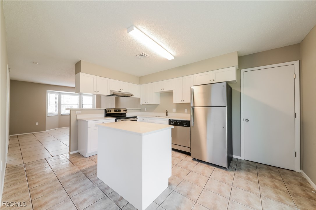 3286 Papaya Road Venice, FL 34293 - Photo 7 of 16 a kitchen with a refrigerator a stove top oven and kitchen island