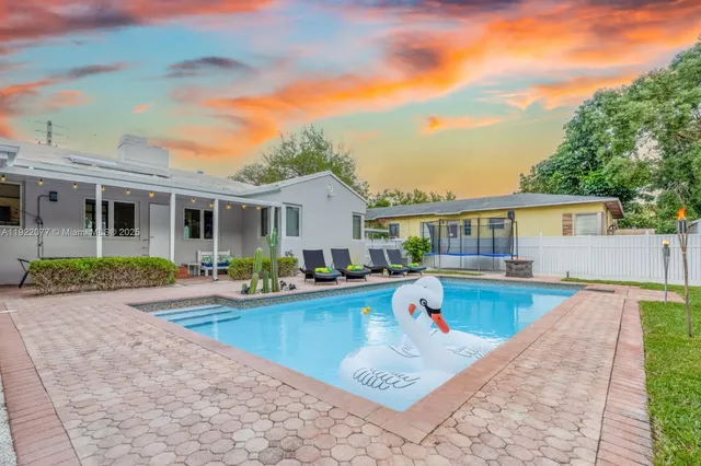 a view of a house with swimming pool and sitting area