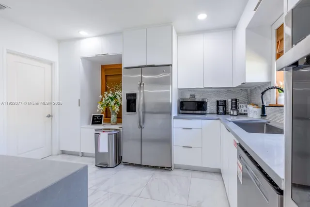a kitchen with a refrigerator sink and cabinets