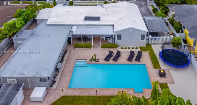 an aerial view of a house with garden space and furniture