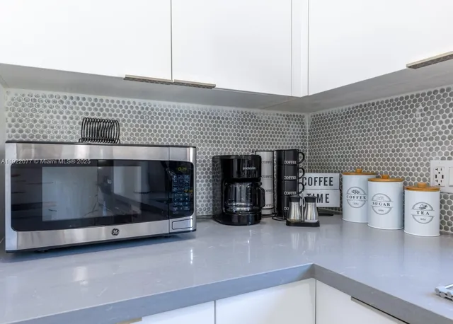 a kitchen with stainless steel appliances wooden floor and a sink