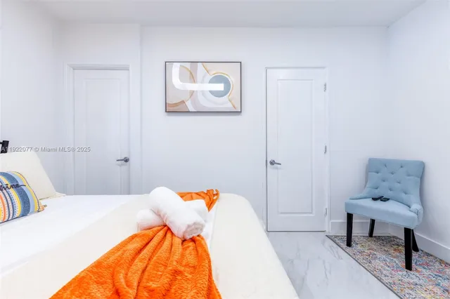 a bedroom with a bed and painting on the wall