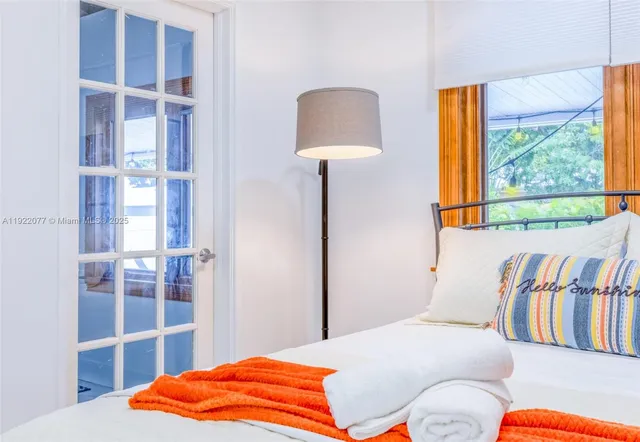 a bedroom with a bed and a lamp on dresser