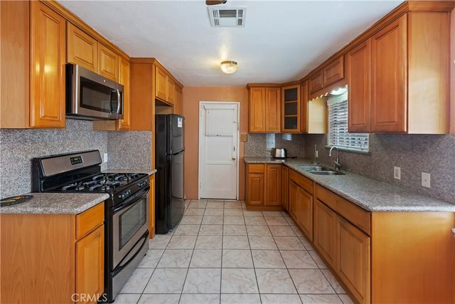 a kitchen with stainless steel appliances granite countertop a stove a sink and a microwave