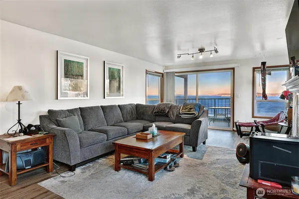 a living room with furniture a flat screen tv and a window