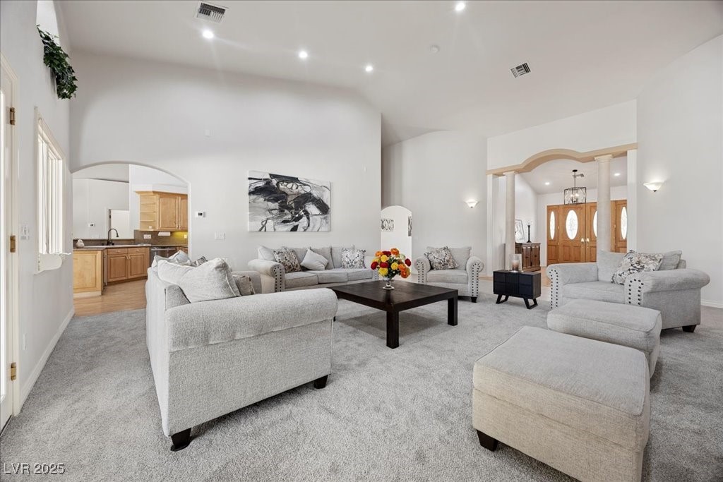 640 Quail Covey Road Henderson, NV 89002 - Photo 7 of 75 Living room with light colored carpet, arched walkways, recessed lighting, and high vaulted ceiling