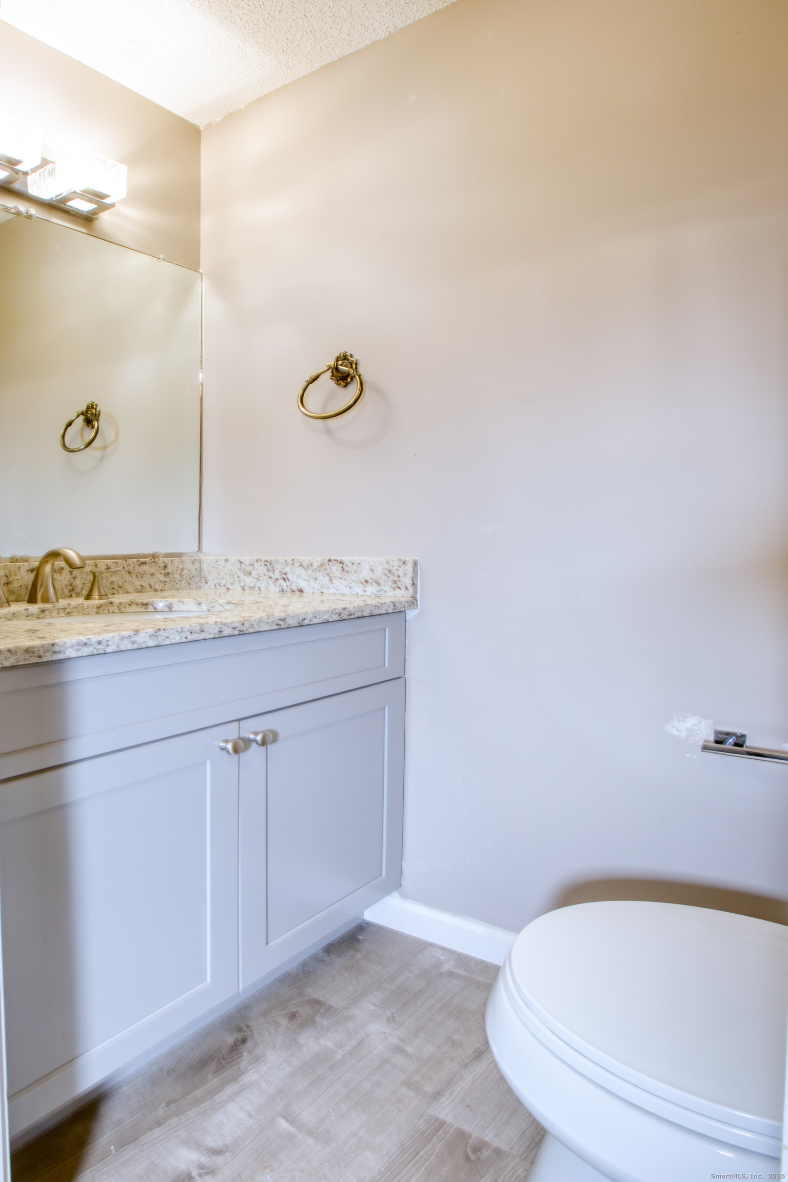 12 Clancy Road, Unit A Branford, CT 06405 - Photo 17 of 31 a bathroom with a granite countertop sink and a mirror