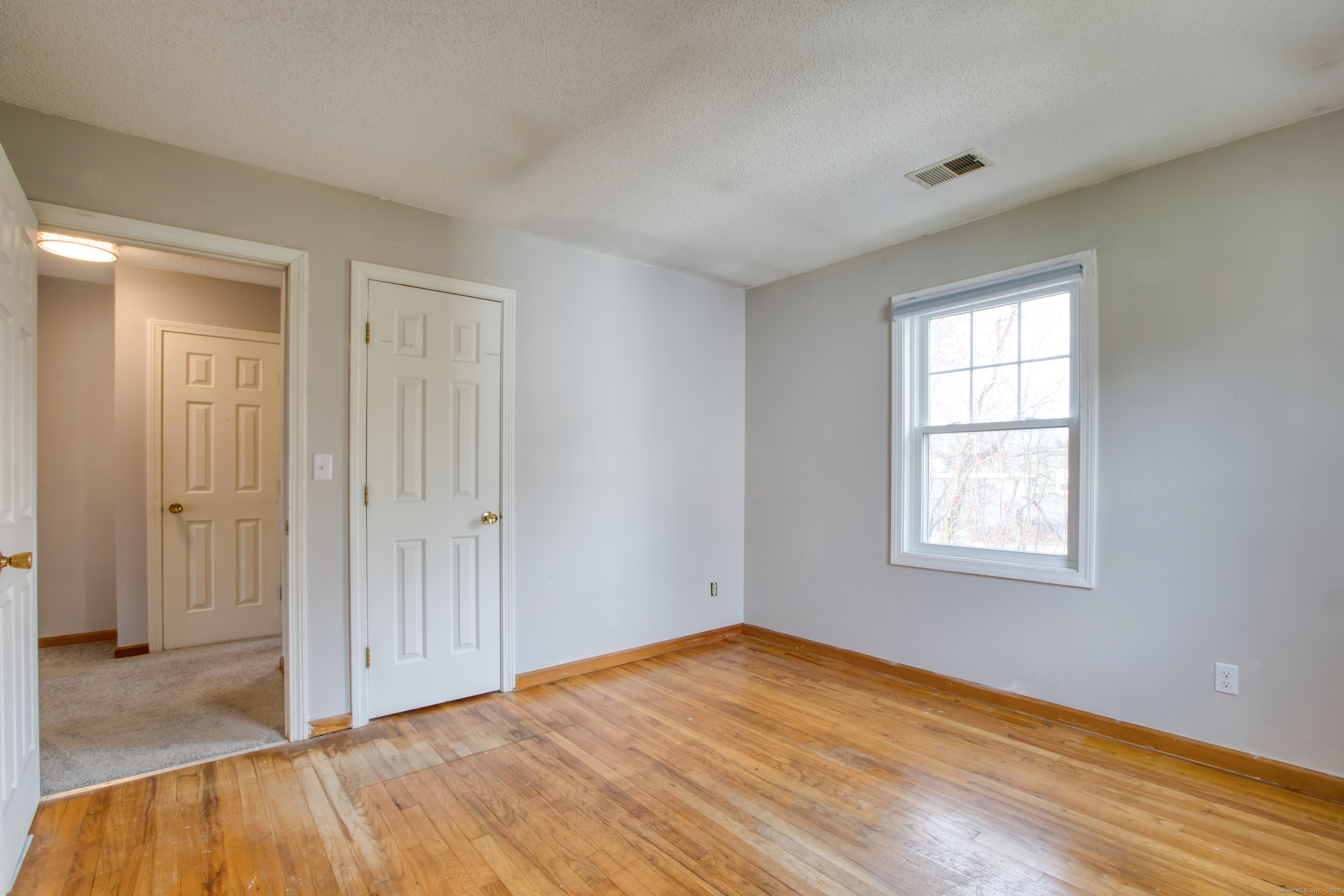 12 Clancy Road, Unit A Branford, CT 06405 - Photo 23 of 31 an empty room with wooden floor and windows