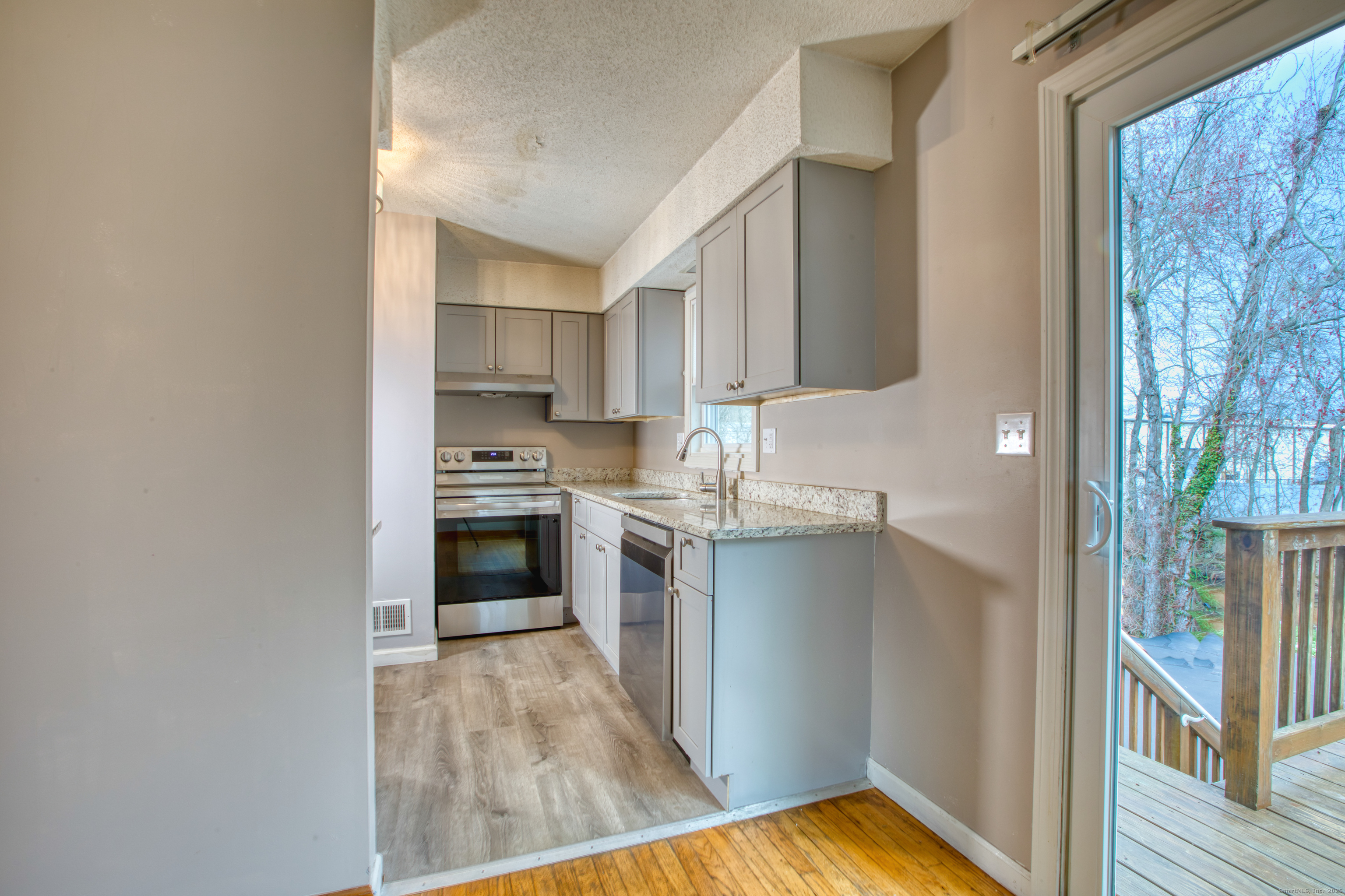 12 Clancy Road, Unit A Branford, CT 06405 - Photo 5 of 31 a kitchen with a refrigerator and a stove top oven
