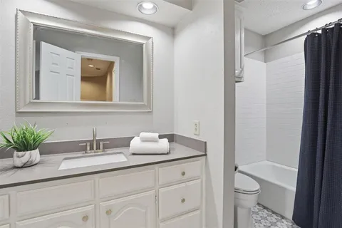a bathroom with a granite countertop sink a toilet and a mirror