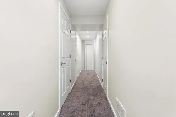 a view of a hallway with wooden floor and a window