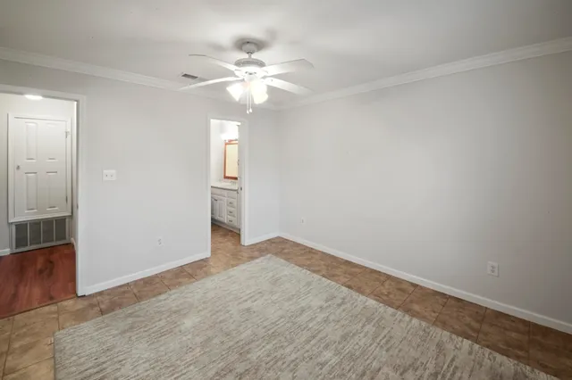an empty room with wooden floor and fan