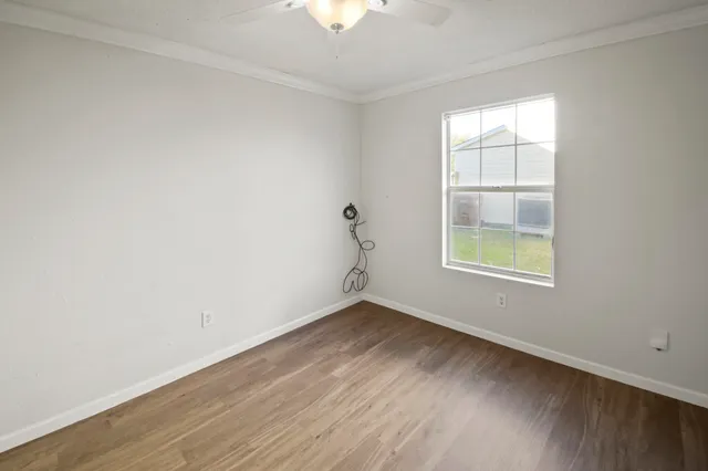 an empty room with a window and a ceiling fan