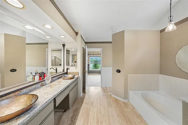 a spacious bathroom with a tub sink shower and mirror