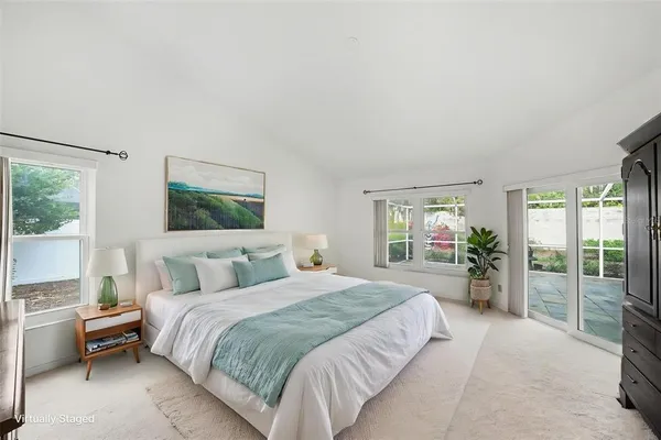 a bedroom with a large bed and a flat tv screen