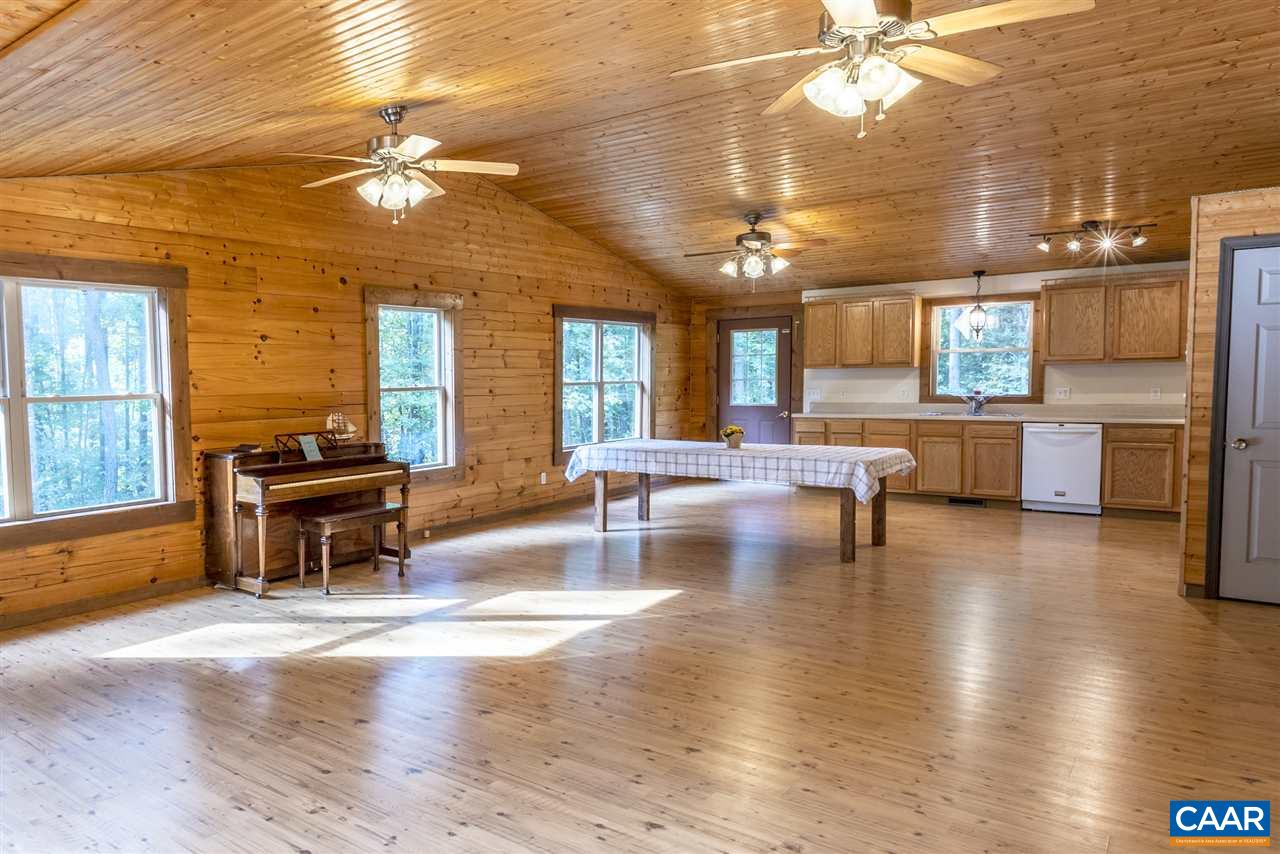 703 George James Loop Radiant, VA 22732 - Photo 2 of 48 an open kitchen with granite countertop a stove kitchen island a sink dishwasher and a fireplace with wooden floor