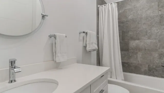 a bathroom with a sink a toilet and shower