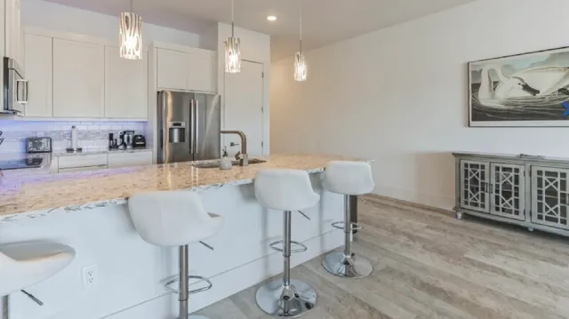 a kitchen with kitchen island granite countertop a refrigerator and a sink
