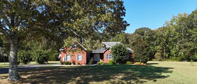 a living room with hardwood floor and large windows