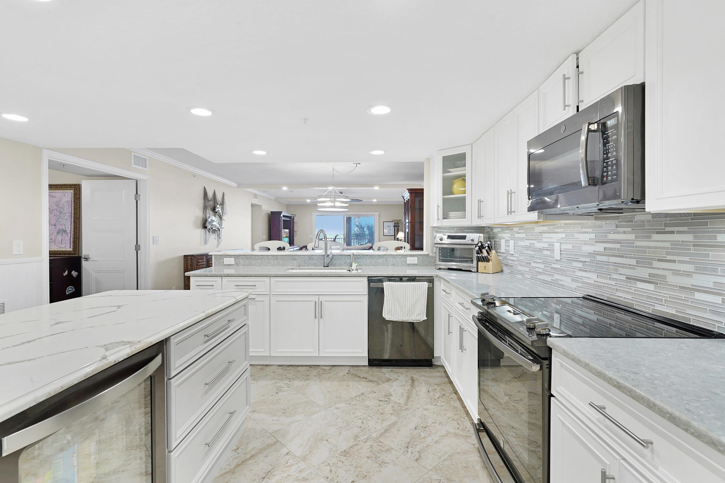33 Comares Avenue, Unit 203 St. Augustine, FL 32080 - Photo 10 of 39 Kitchen with appliances with stainless steel finishes, white cabinets, glass insert cabinets, recessed lighting, and crown molding