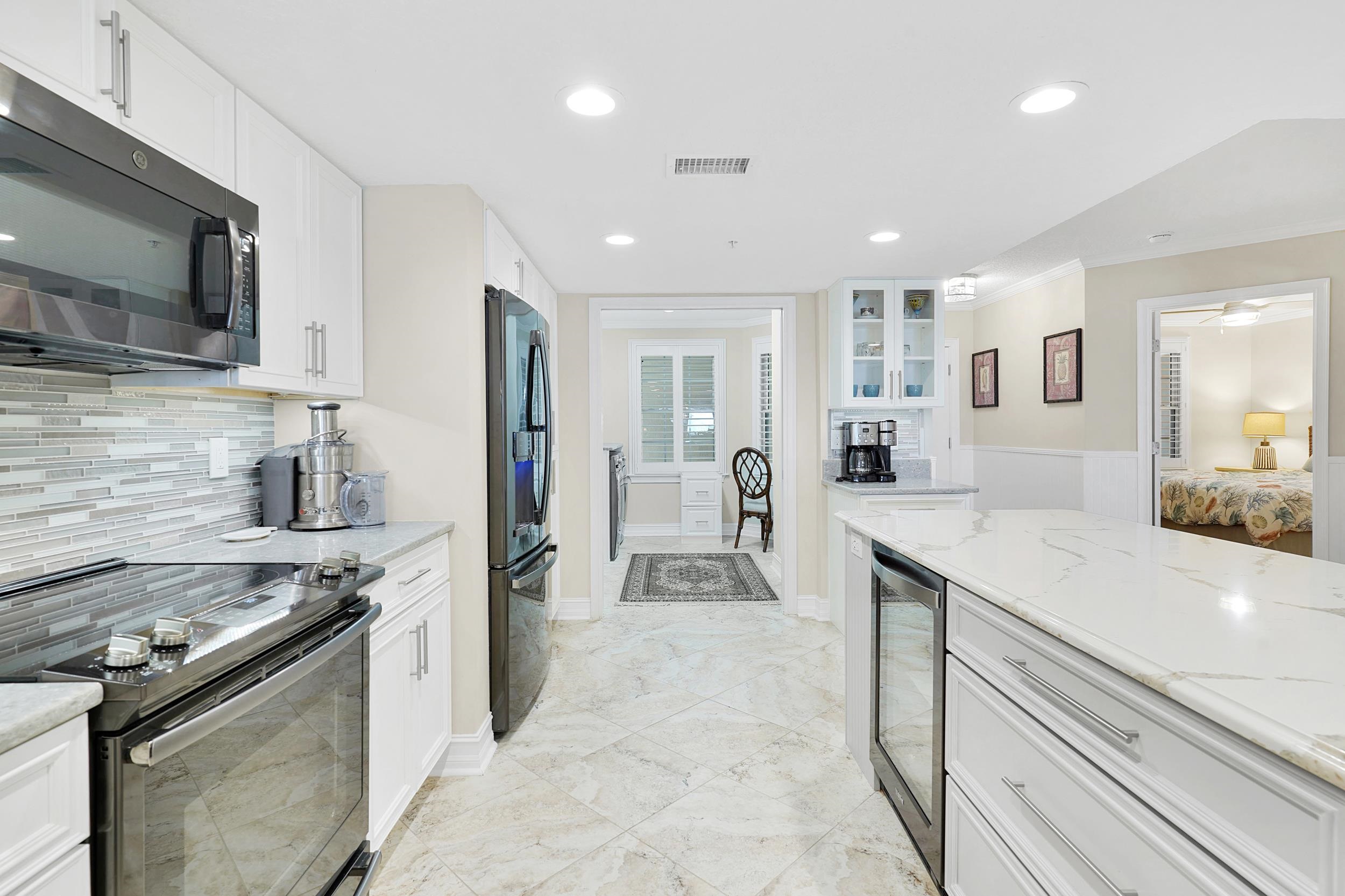33 Comares Avenue, Unit 203 St. Augustine, FL 32080 - Photo 11 of 39 Kitchen featuring electric stove, white cabinetry, recessed lighting, light stone countertops, and crown molding
