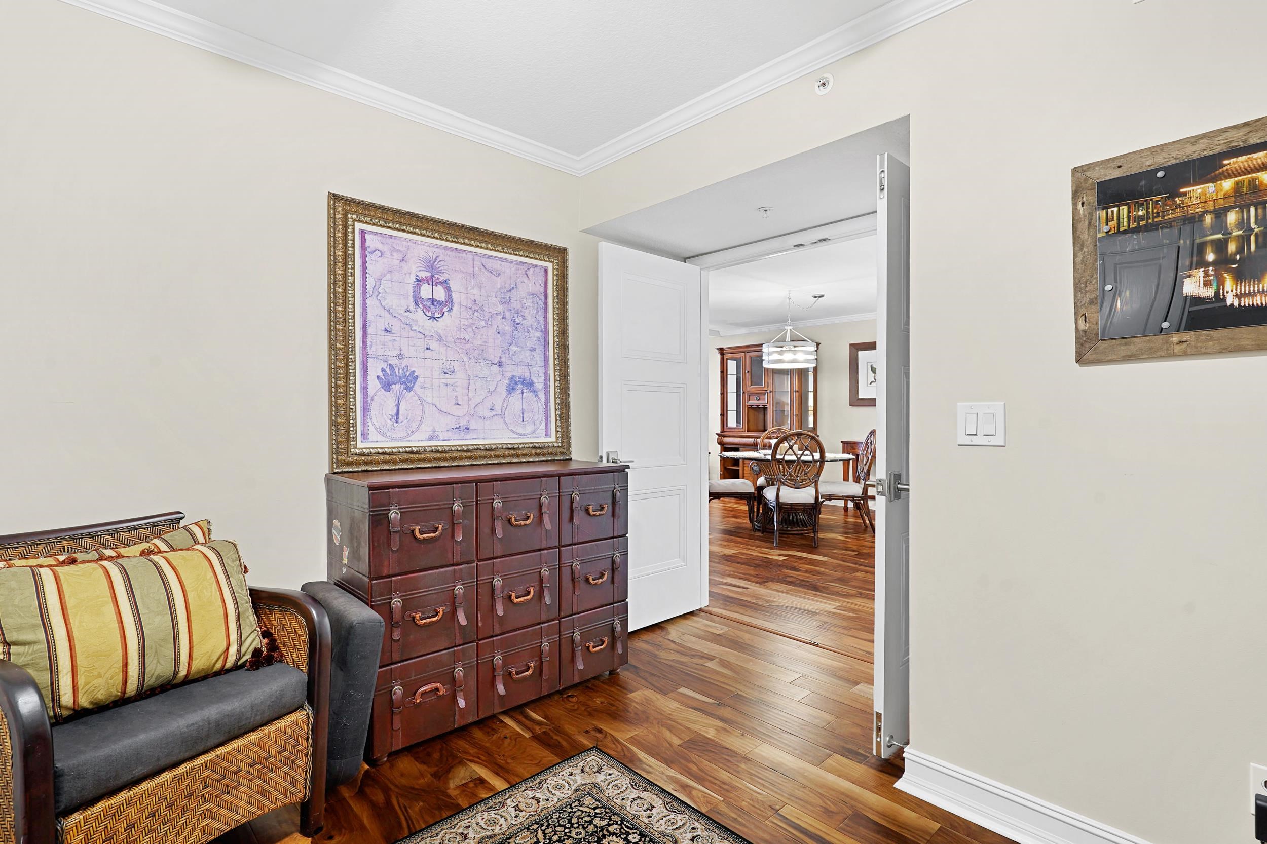 33 Comares Avenue, Unit 203 St. Augustine, FL 32080 - Photo 19 of 39 Living area with crown molding and dark wood finished floors