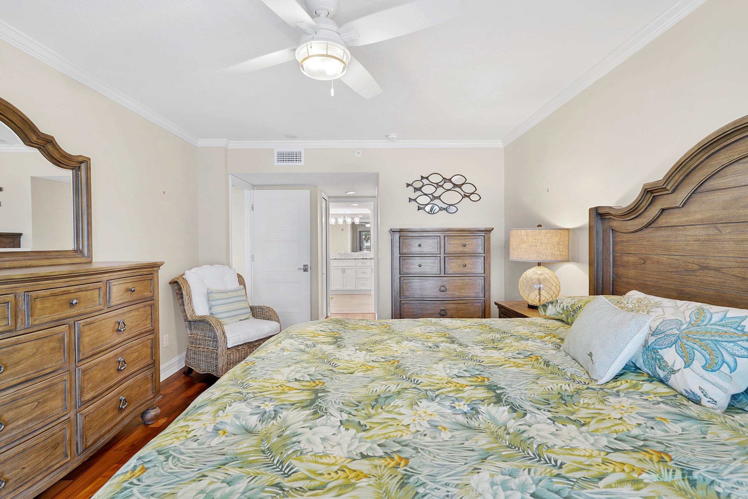 33 Comares Avenue, Unit 203 St. Augustine, FL 32080 - Photo 23 of 39 Bedroom with dark wood-style flooring, a ceiling fan, ensuite bath, and crown molding