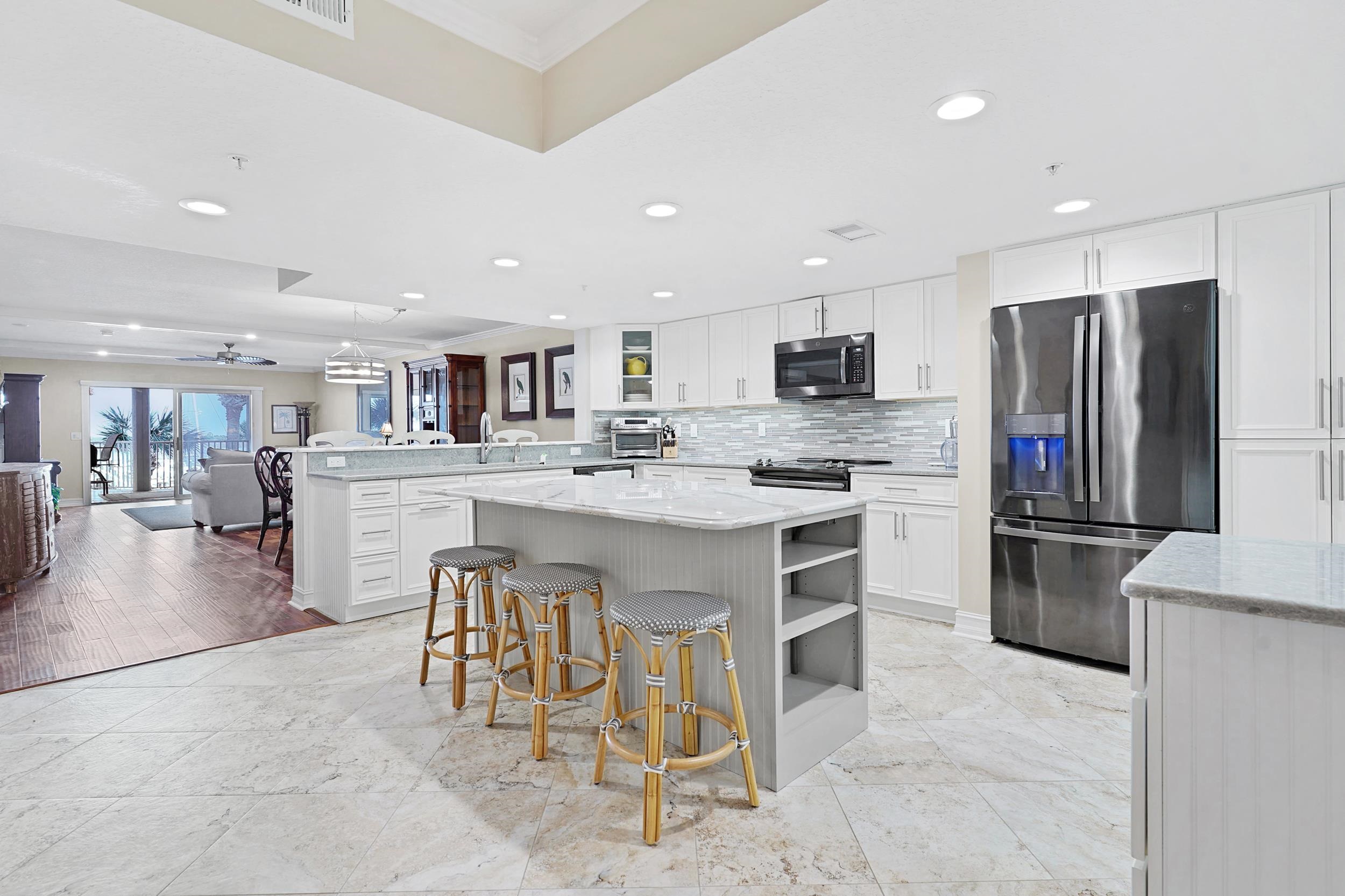 33 Comares Avenue, Unit 203 St. Augustine, FL 32080 - Photo 39 of 39 Kitchen featuring a breakfast bar area, appliances with stainless steel finishes, a peninsula, open shelves, and open floor plan