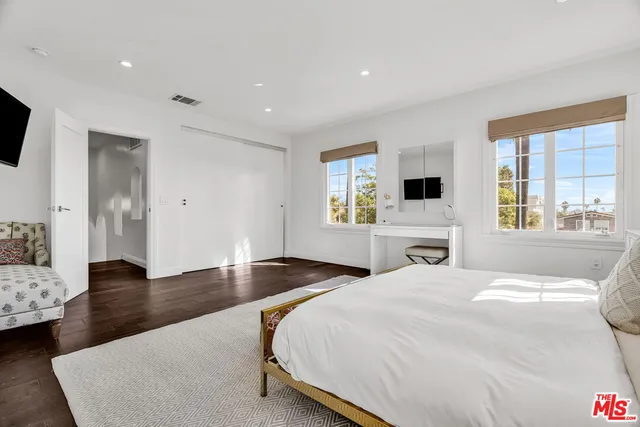 a bedroom with a bed and paintings on the wall
