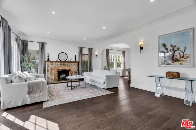 a kitchen with a stove a sink dishwasher a dining table and chairs with wooden floor