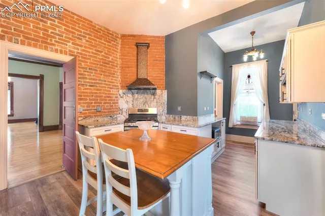 a view of a kitchen with kitchen island a sink and a refrigerator