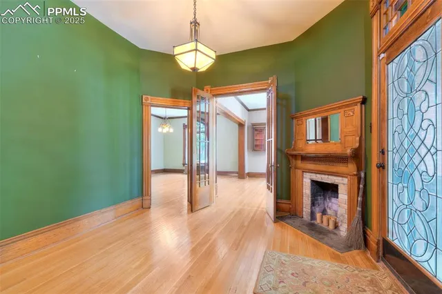 a view of a livingroom with wooden floor a ceiling fan and a window