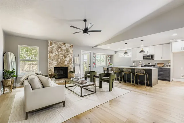 a living room with furniture a fireplace and a kitchen view