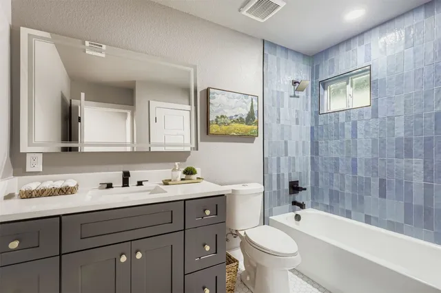 a bathroom with a double vanity sink toilet and shower