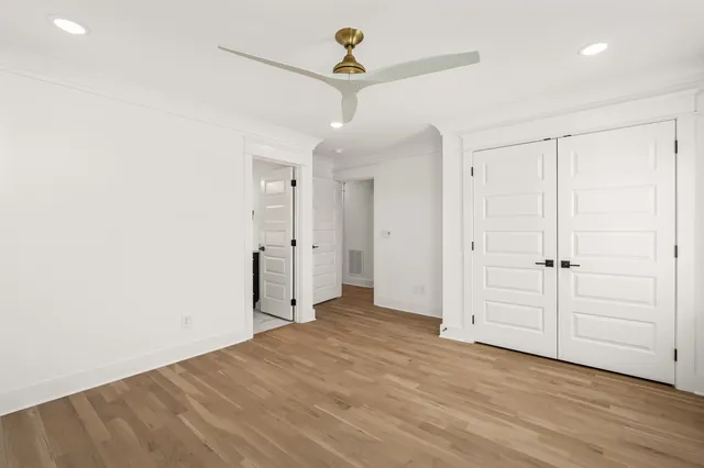 a view of a livingroom with wooden floor and a ceiling fan
