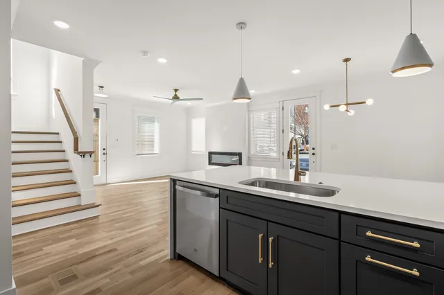 a kitchen with a sink and dishwasher wooden floor